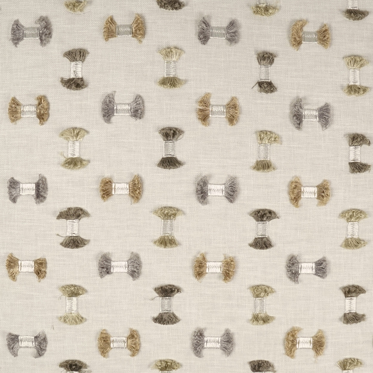 Light beige linen-like fabric with repeating small spool motifs in muted brown, grey, and olive tones.