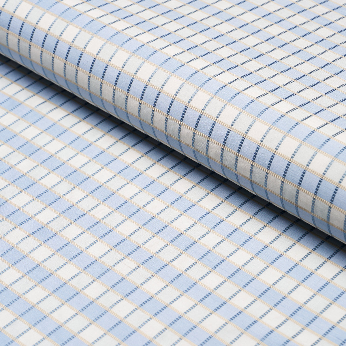 Rolled light blue and white checkered fabric with fine beige and blue stripes.