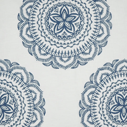 Blue mandala-style circular motifs on white fabric, featuring intricate concentric patterns.