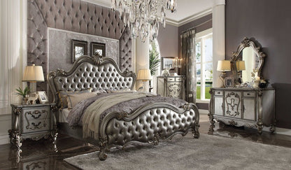 Luxurious silver tufted bed with ornate carved frame, matching nightstands, dresser and mirror in glam metallic decor.