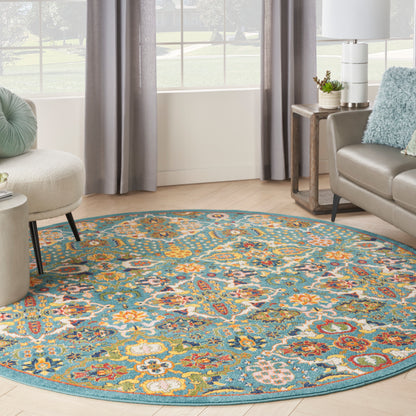 Round teal rug with a vivid multicolor floral pattern on light wood flooring in a modern living room.