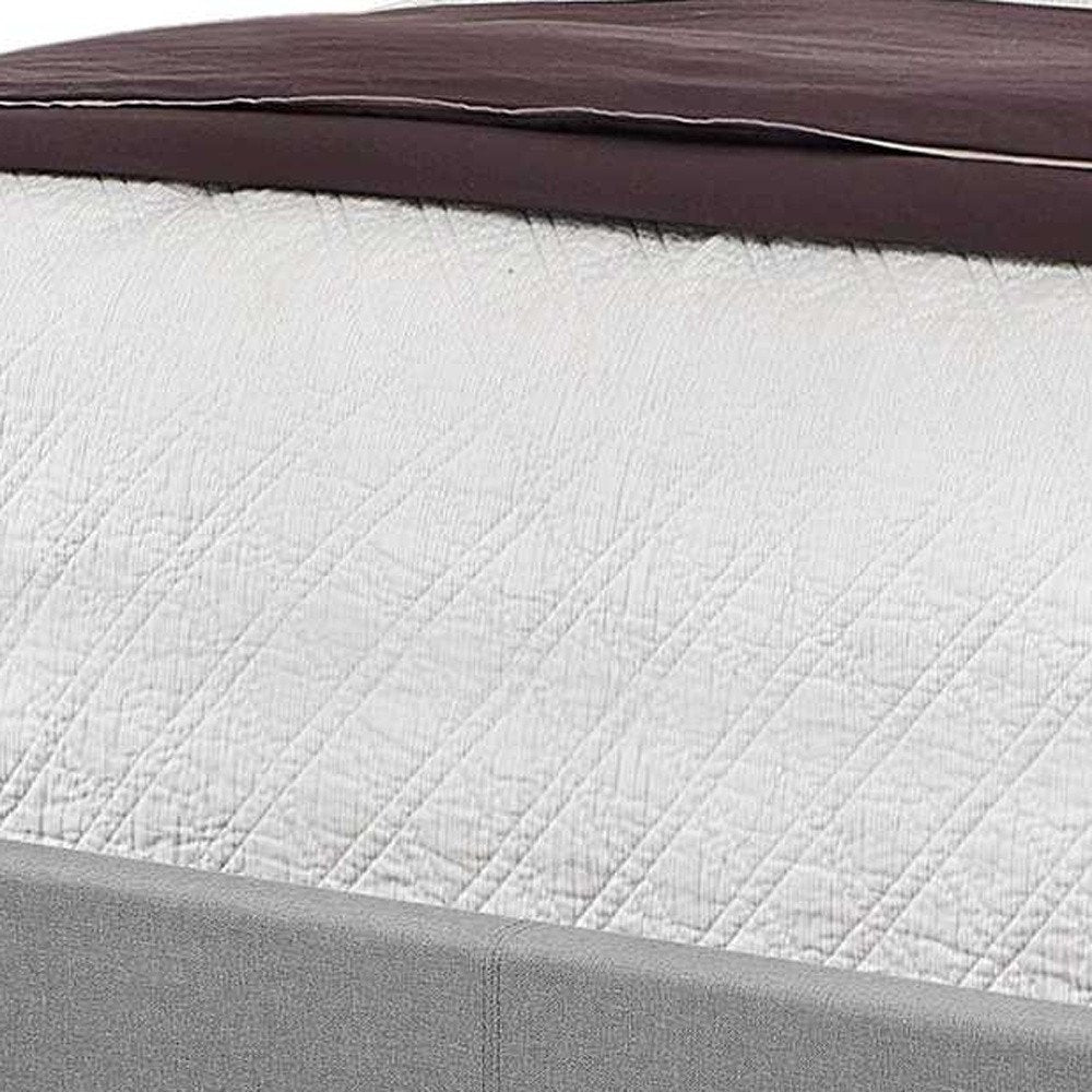 Solid wood queen bed with tufted gray upholstered linen and nailhead trim.