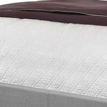 Solid wood queen bed with tufted gray upholstered linen and nailhead trim.