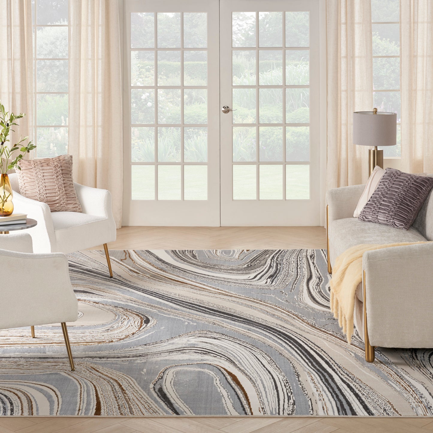 Living room with abstract swirl rug in gray and beige, cream seating, glass French doors, light curtains.