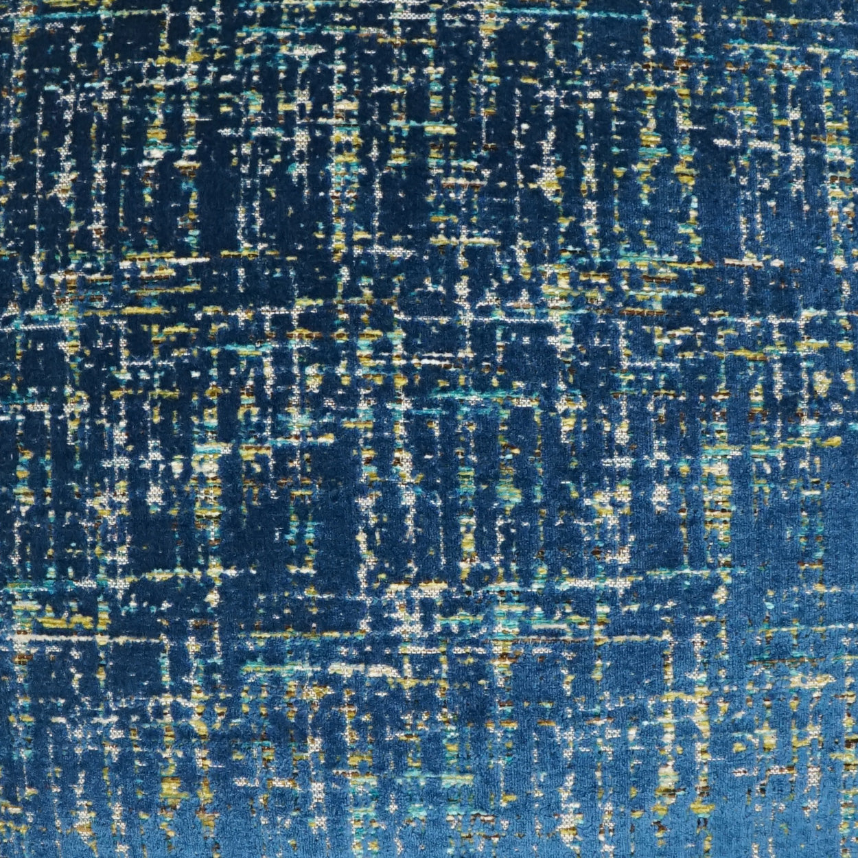 Abstract blue fabric featuring distressed yellow-green streaks and a grid-like pattern.