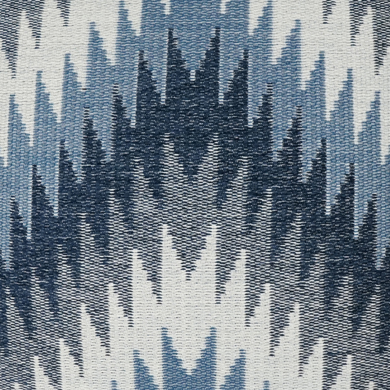 Pillow with ikat-inspired woven fabric featuring navy and light-blue jagged chevron patterns on ivory.