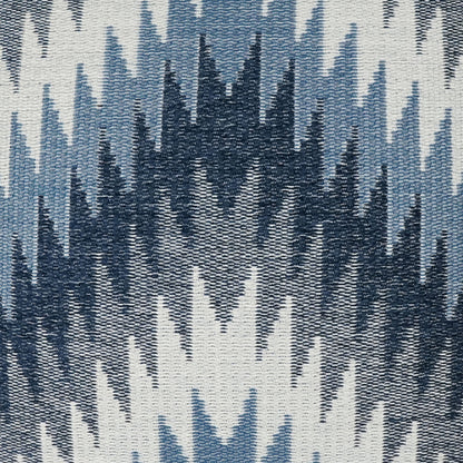 Pillow with ikat-inspired woven fabric featuring navy and light-blue jagged chevron patterns on ivory.