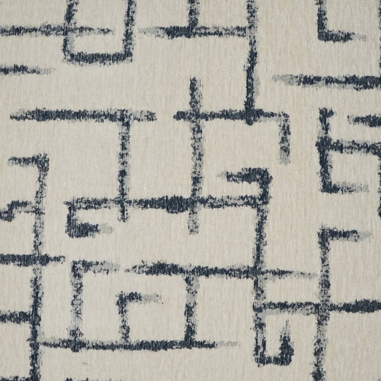 Cream fabric with navy blue geometric maze lines; a woven textile for upholstery & drapery.