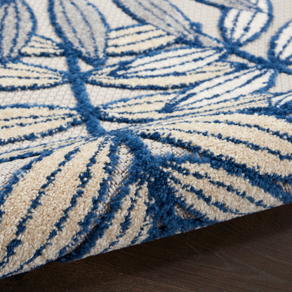 Rectangular ivory rug with blue palm-leaf motif, tufted loop-pile for living room decor.