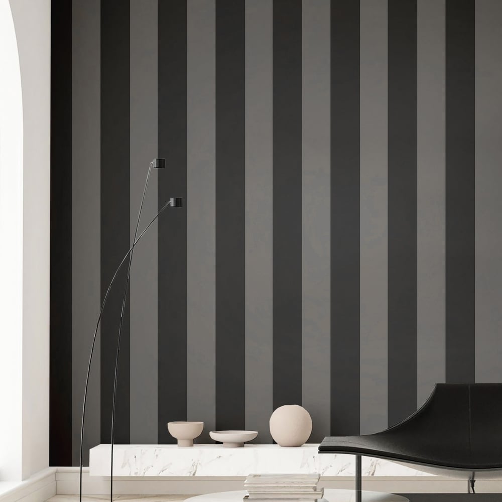 Modern corner with anthracite wide-stripe wallpaper, marble shelf, bowls, spherical decor, tall arc lamp, and black curved lounge chair.