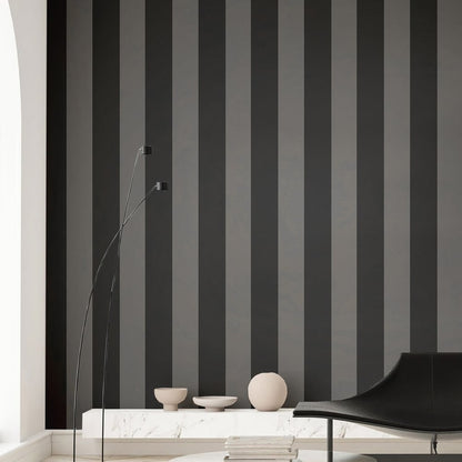 Modern corner with anthracite wide-stripe wallpaper, marble shelf, bowls, spherical decor, tall arc lamp, and black curved lounge chair.