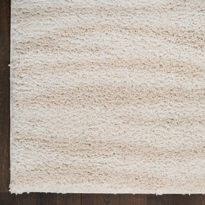 Cream beige shag rug with thick plush pile on dark wood flooring; cozy modern accent for living room or bedroom.