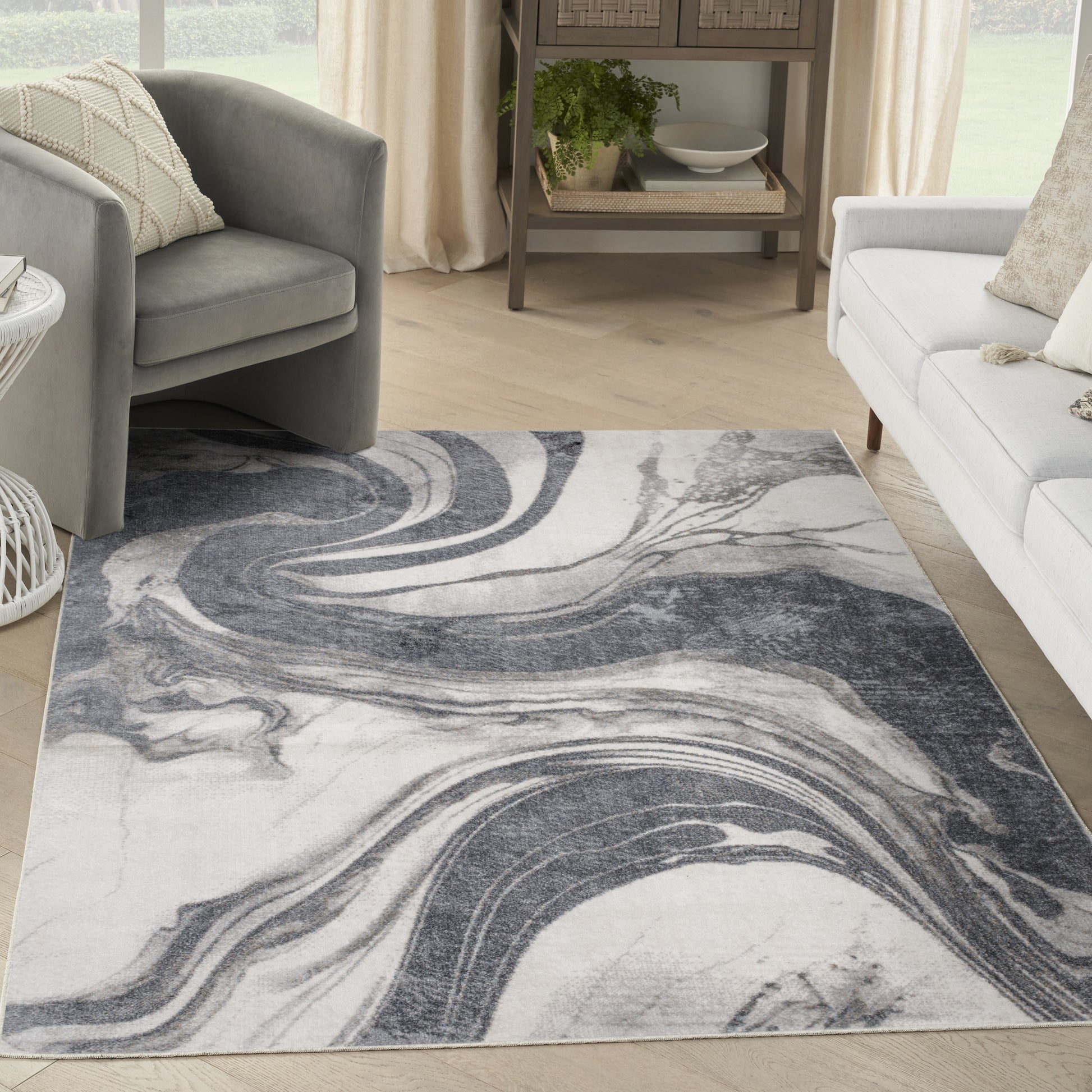Rectangular marbled rug in gray, white and navy with swirling pattern, in a bright living room.