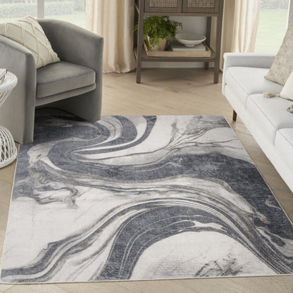 Rectangular marbled rug in gray, white and navy with swirling pattern, in a bright living room.