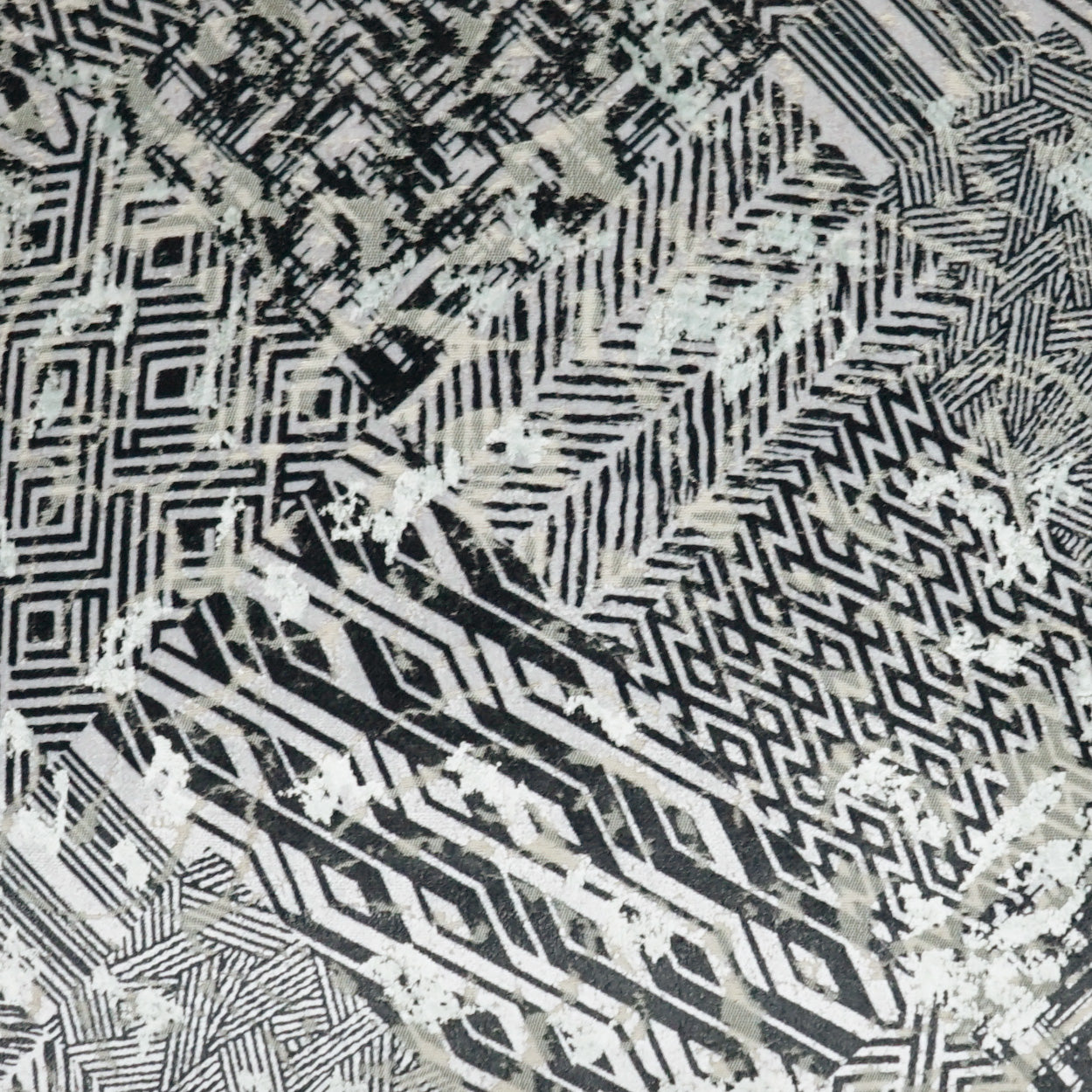 Monochrome woven pillow with black, white & gray geometric patterns, including chevrons and diamonds (24 x 24 inches).