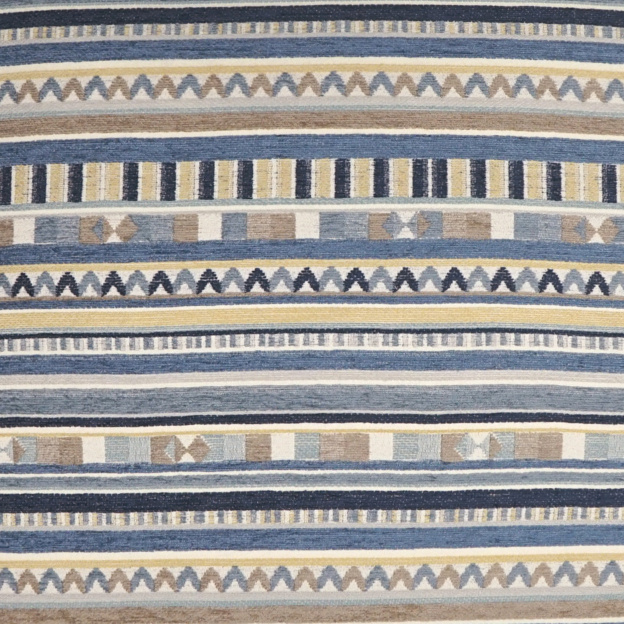 Striped woven fabric in blue, navy, beige and ivory with zigzag and geometric motifs; suitable for upholstery or decor.