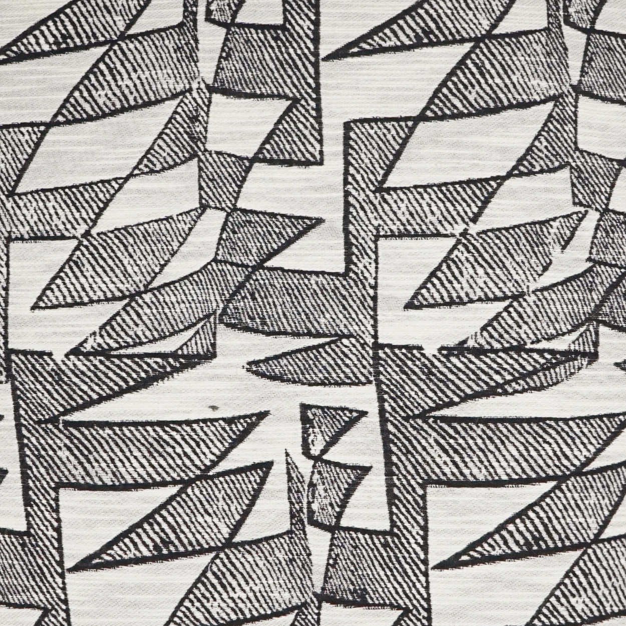 Cream fabric with repeating black angular geometric leaf shapes and crosshatched shading.