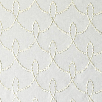 Cream chain-stitch embroidery on white upholstery fabric forming a repeating scalloped loop pattern; textured fabric.
