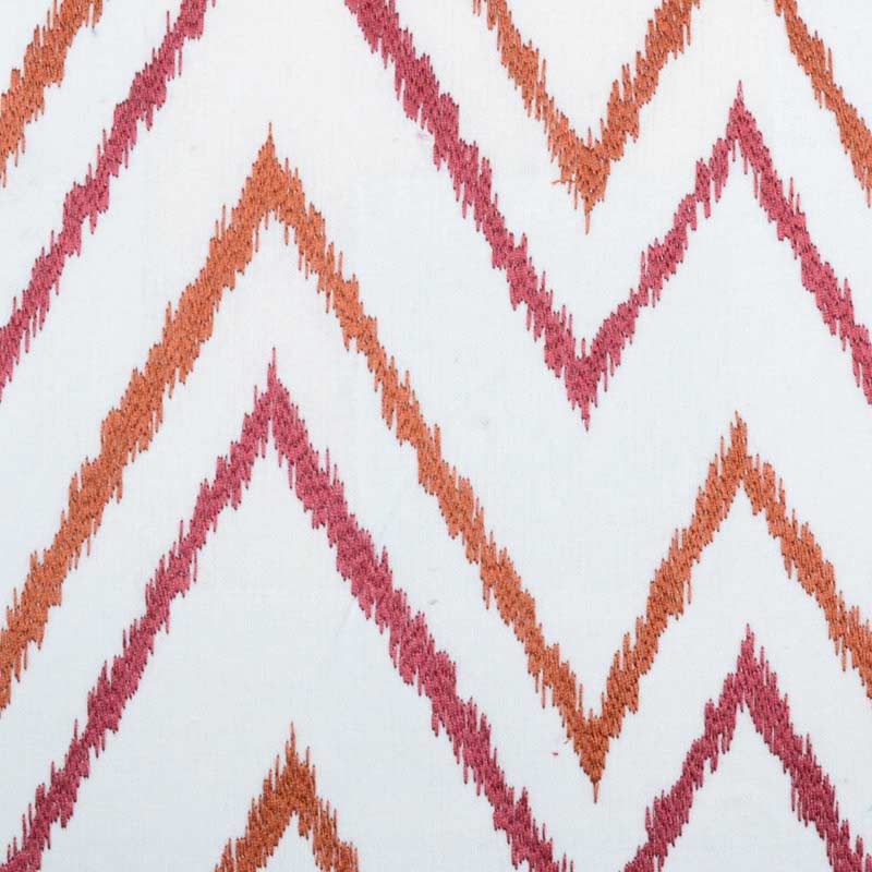 White fabric with orange and pink chevron zigzag pattern; textured knit-like textile.