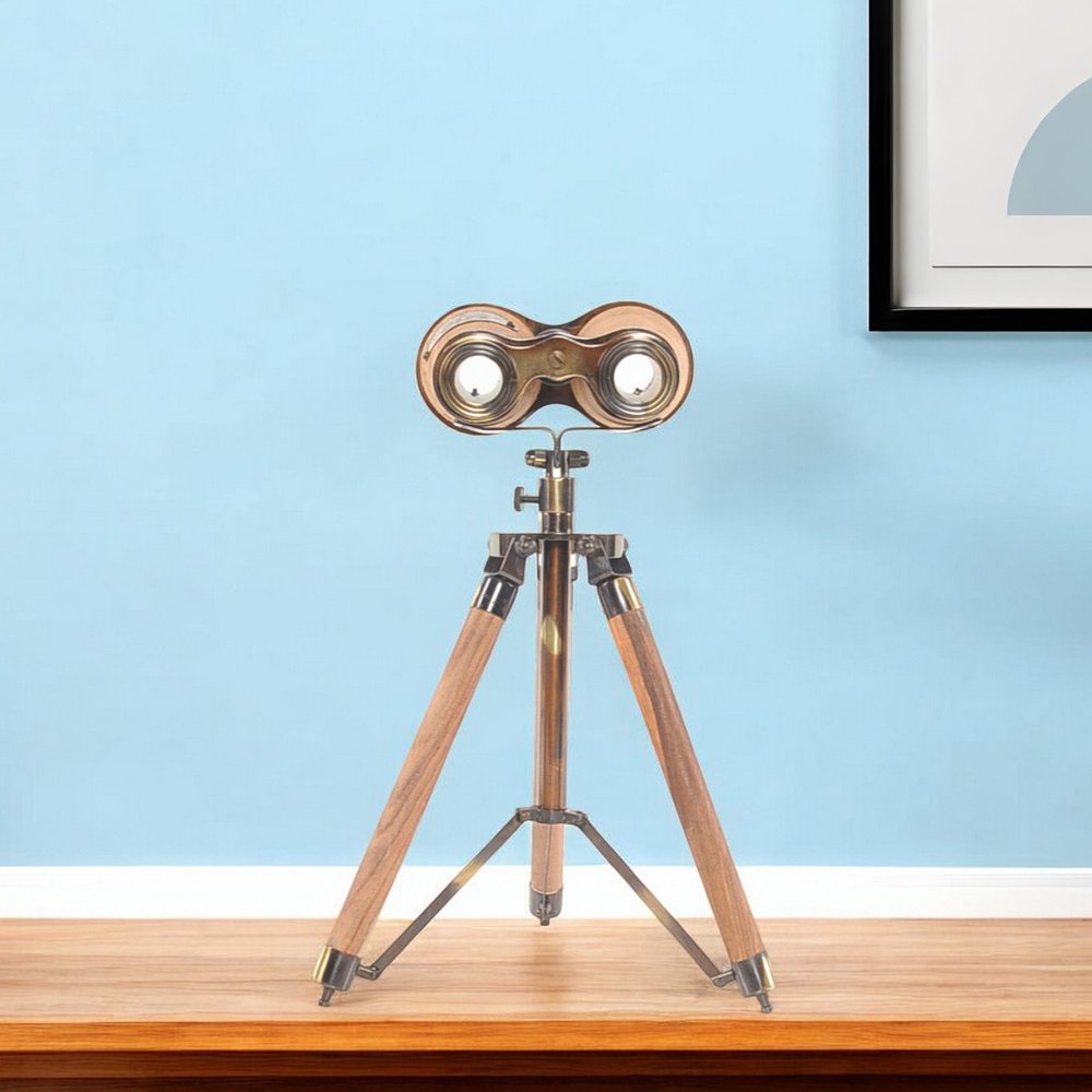 Brass binoculars on a wooden tripod with metal fittings, vintage steampunk decor against a blue wall.
