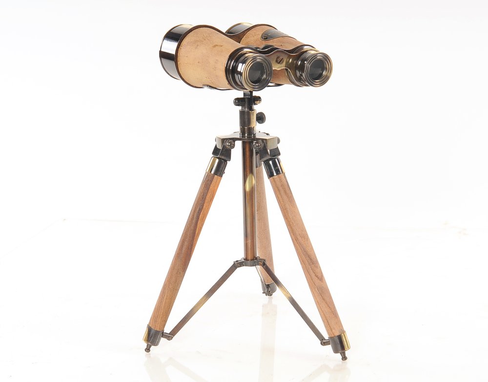 Antique wooden binoculars with brass fittings mounted on a wooden tripod.