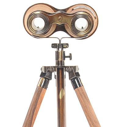 Antique brass binoculars with twin lenses mounted on a wooden tripod stand, vintage steampunk style.