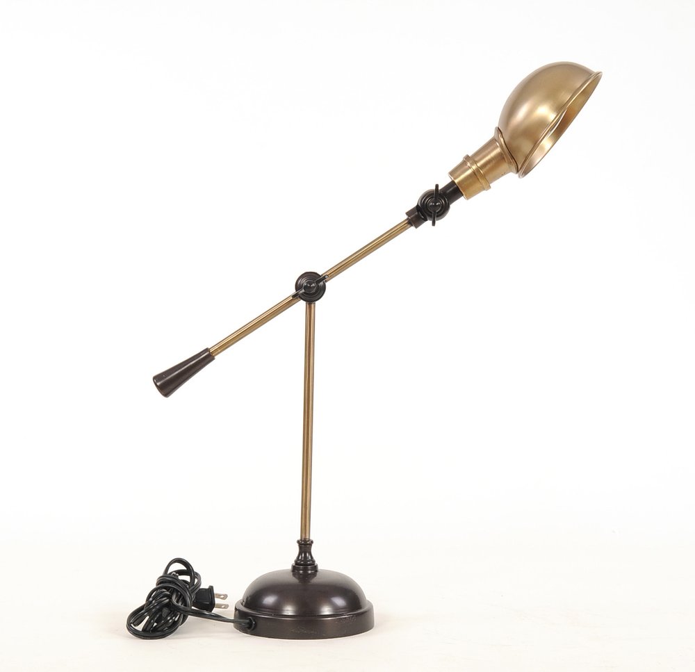 Brass adjustable desk lamp with black joint knobs, dome shade, on round dark base with cord