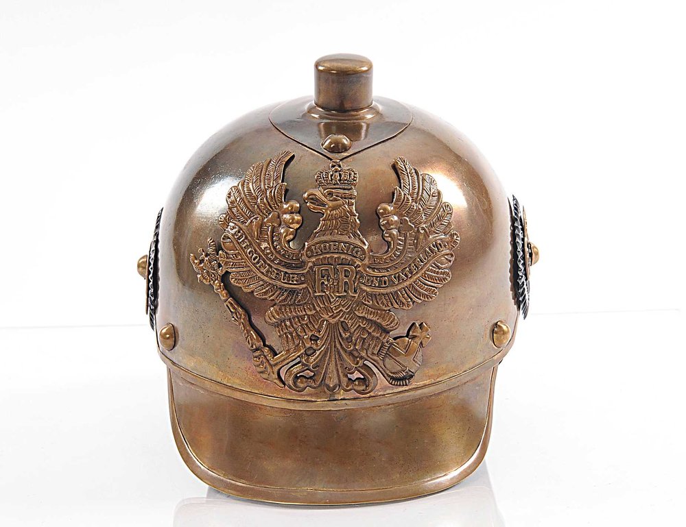 Bronze-toned metal helmet with embossed double-eagle crest, crown and ornate wings; riveted sides and curved brim.