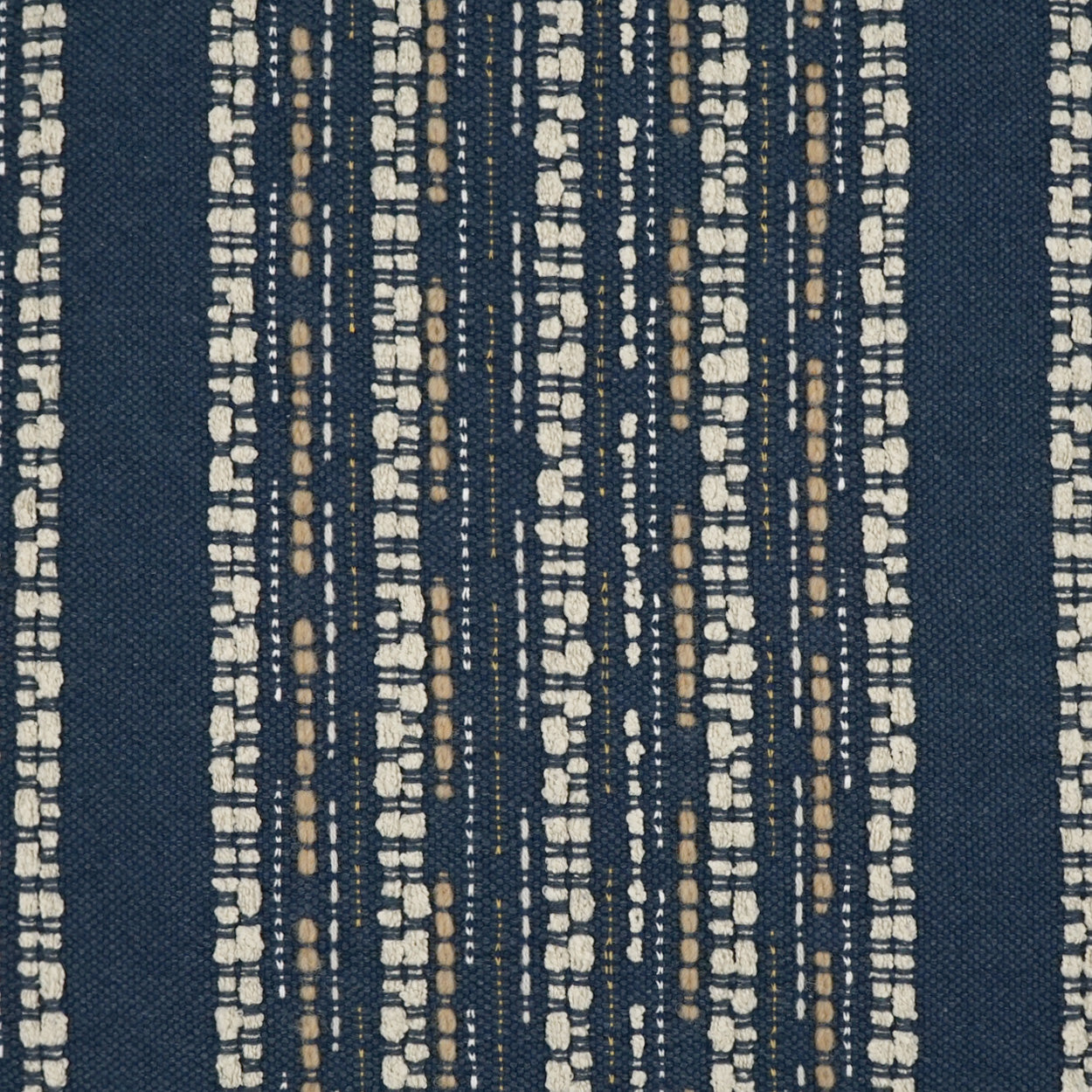 Navy blue woven fabric with vertical cream and tan dotted stripes.