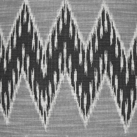 Gray woven fabric with bold black jagged chevron/ikat pattern; geometric textile for upholstery or drapery.