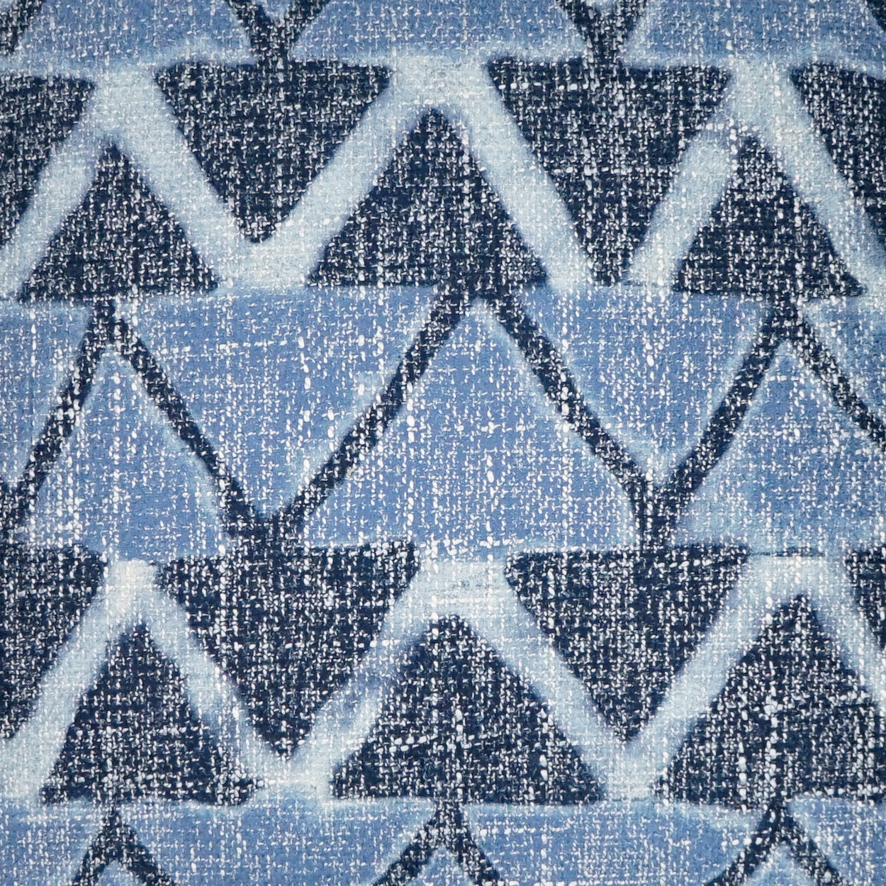 Blue geometric zigzag knit fabric with light/dark blue triangles and speckled texture.