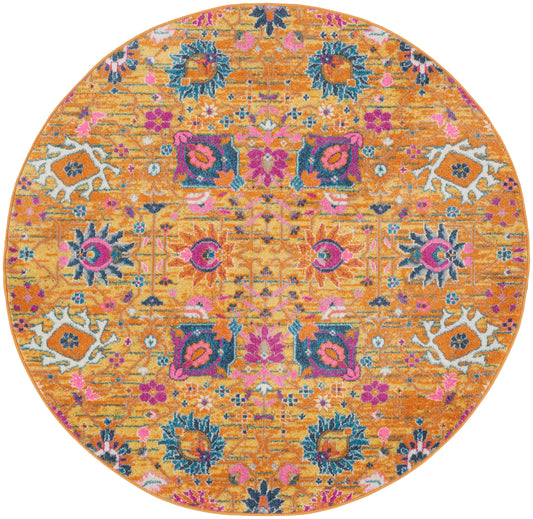 Round orange rug with bright pink, teal and purple floral motifs in an ornate oriental/kilim design.