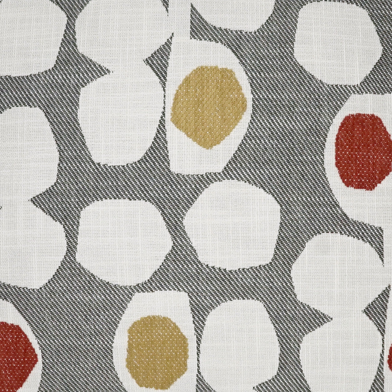 Grey woven fabric with white irregular blob shapes and small gold and red accent spots; abstract upholstery print.