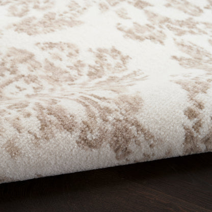 Cream & beige damask-patterned plush rug, round 5' diameter, on dark wood floor.