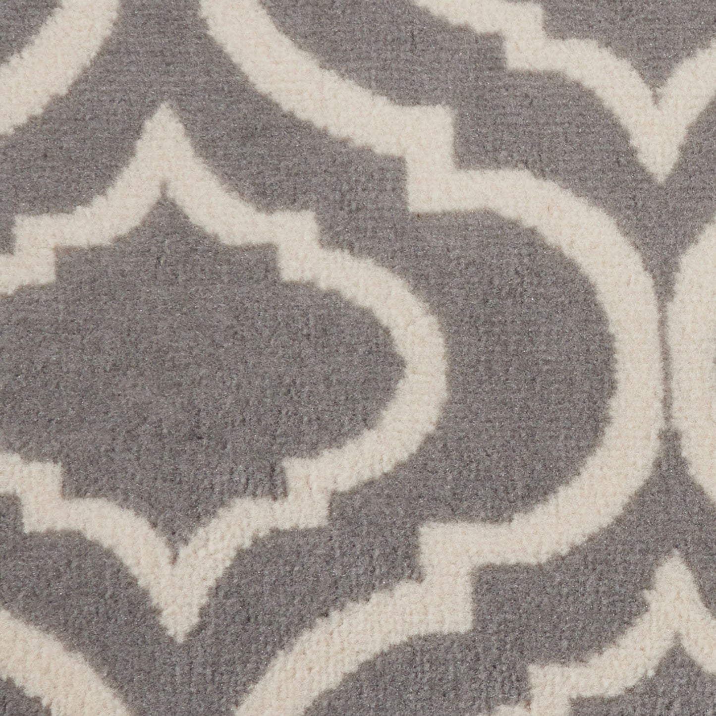 Grey rug with white Moroccan trellis pattern; soft woven texture, close-up.