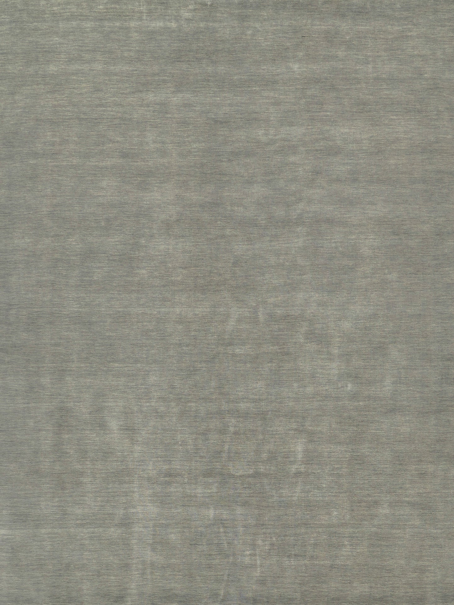 Gray textured rug with a soft brushed surface and a faint circular medallion pattern.