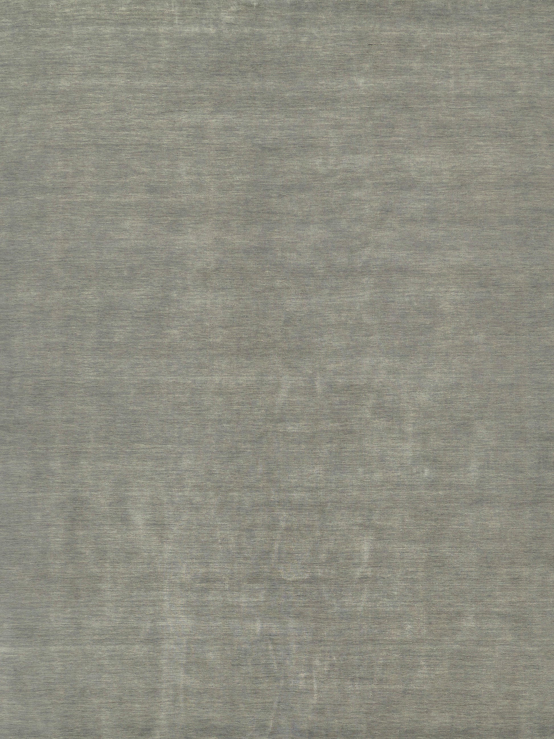 Gray textured rug with a soft brushed surface and a faint circular medallion pattern.