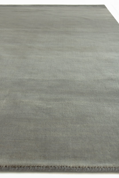 Rectangular wool dove indoor hand-loomed rug with subtle tonal texture and fringe along one edge.