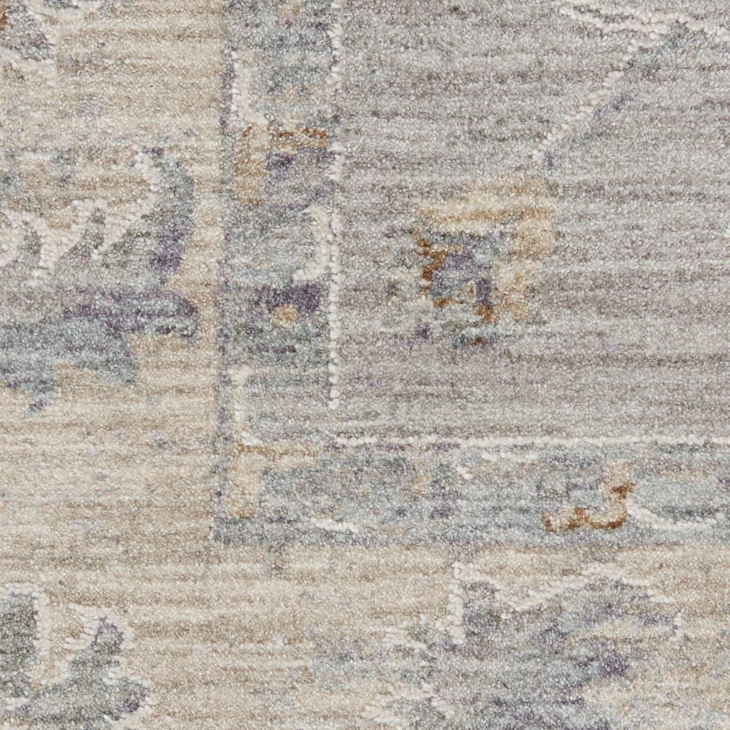 Close-up of a muted gray-beige vintage 10' runner rug with lavender accents and a faded geometric floral pattern.