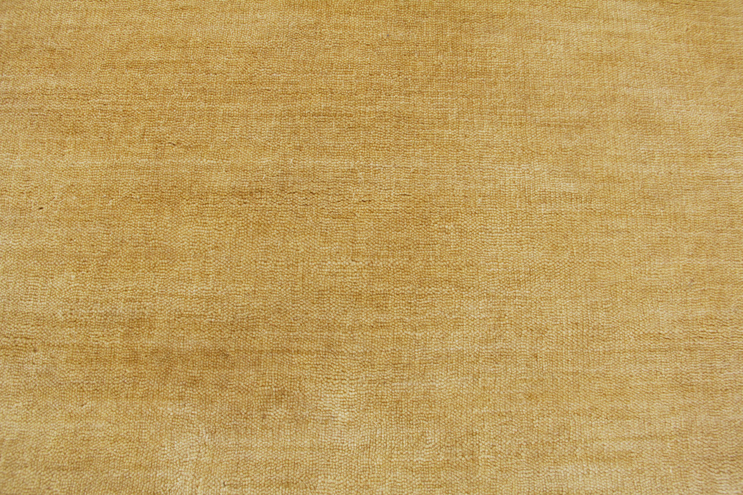 Golden beige wool rug texture with visible woven fibers; hand loomed indoor rug, 8' x 10'.