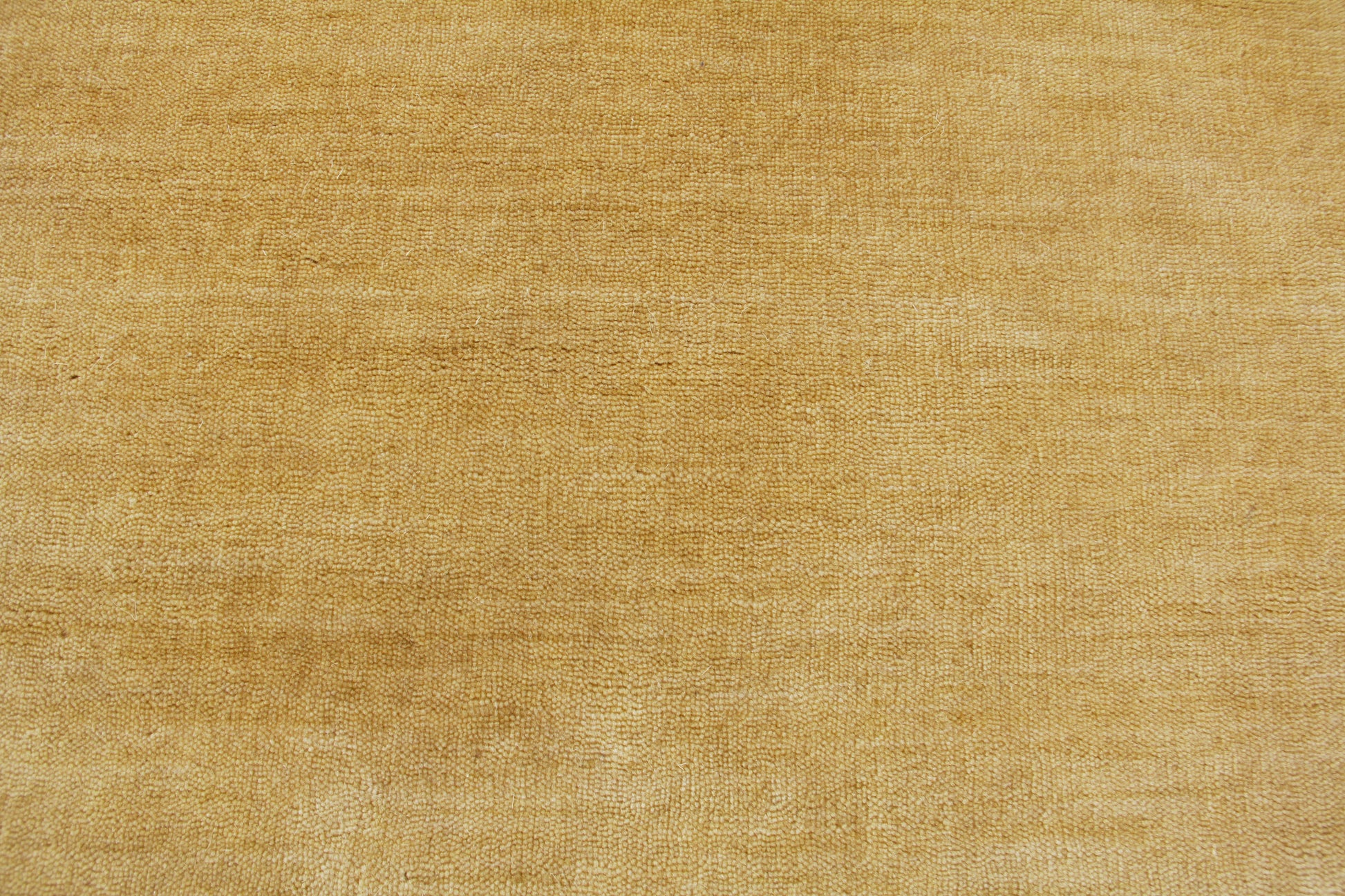 Golden beige wool rug texture with visible woven fibers; hand loomed indoor rug, 8' x 10'.