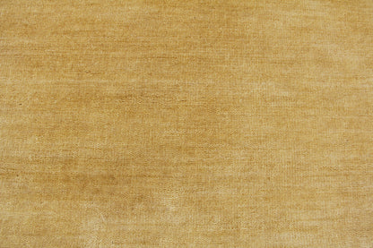 Golden beige wool rug texture with visible woven fibers; hand loomed indoor rug, 8' x 10'.