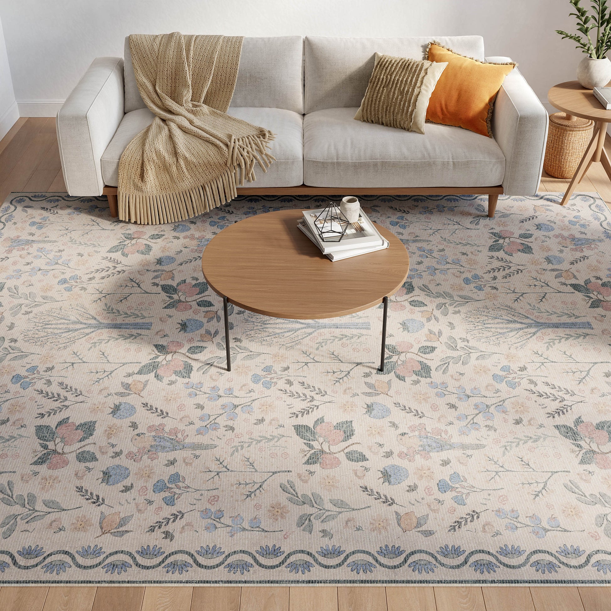 Floral blue-gray rug, 8' x 10'; beige fabric sofa with wooden legs, beige throw and mustard cushions, round wood coffee table.