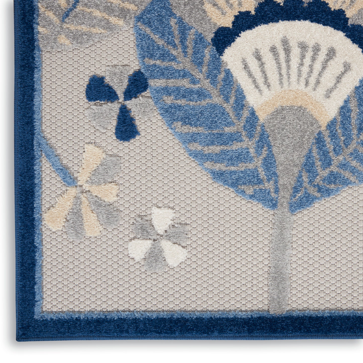 Close-up of a woven textile with a dark blue border, gray field, and blue floral-leaf pattern.