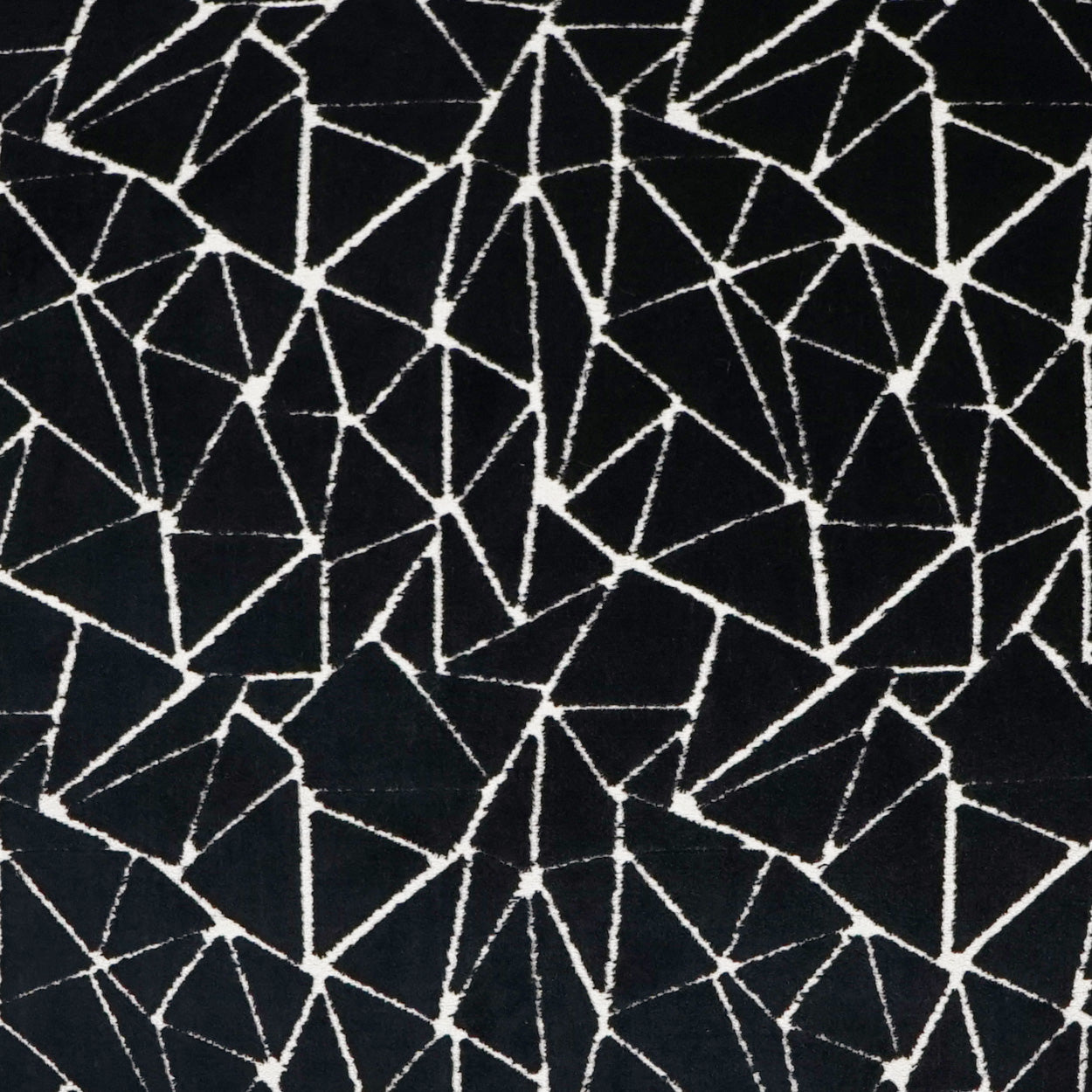Black fabric with white irregular cracked-line geometric pattern forming mosaic shard shapes.