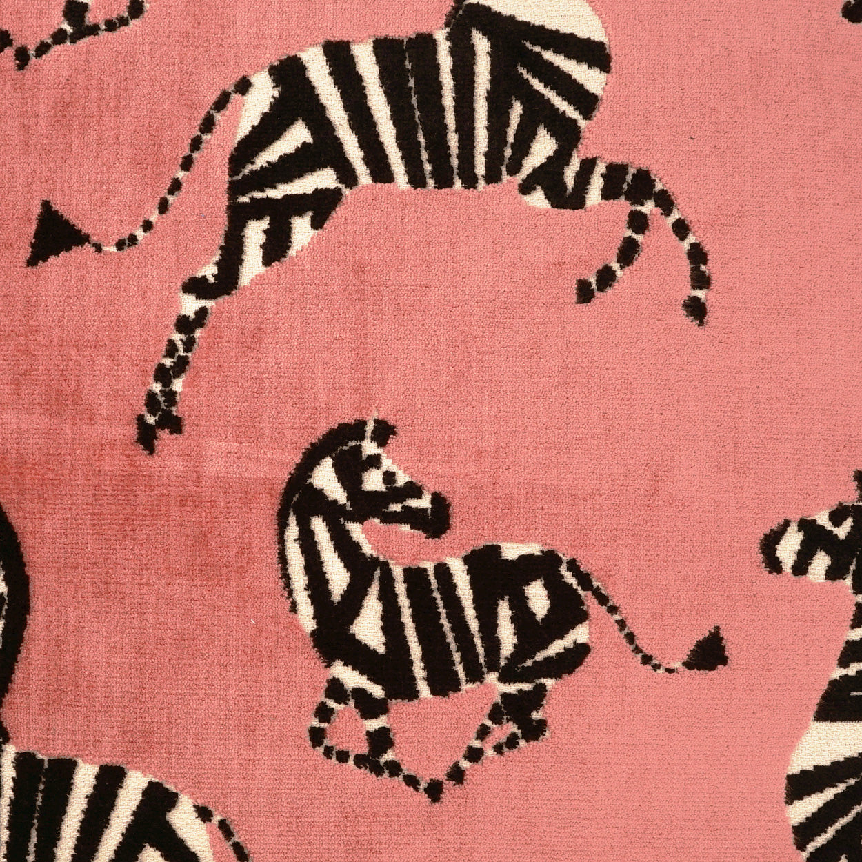 Pink fabric with black-and-white zebra silhouettes; soft woven pattern for upholstery or home décor.