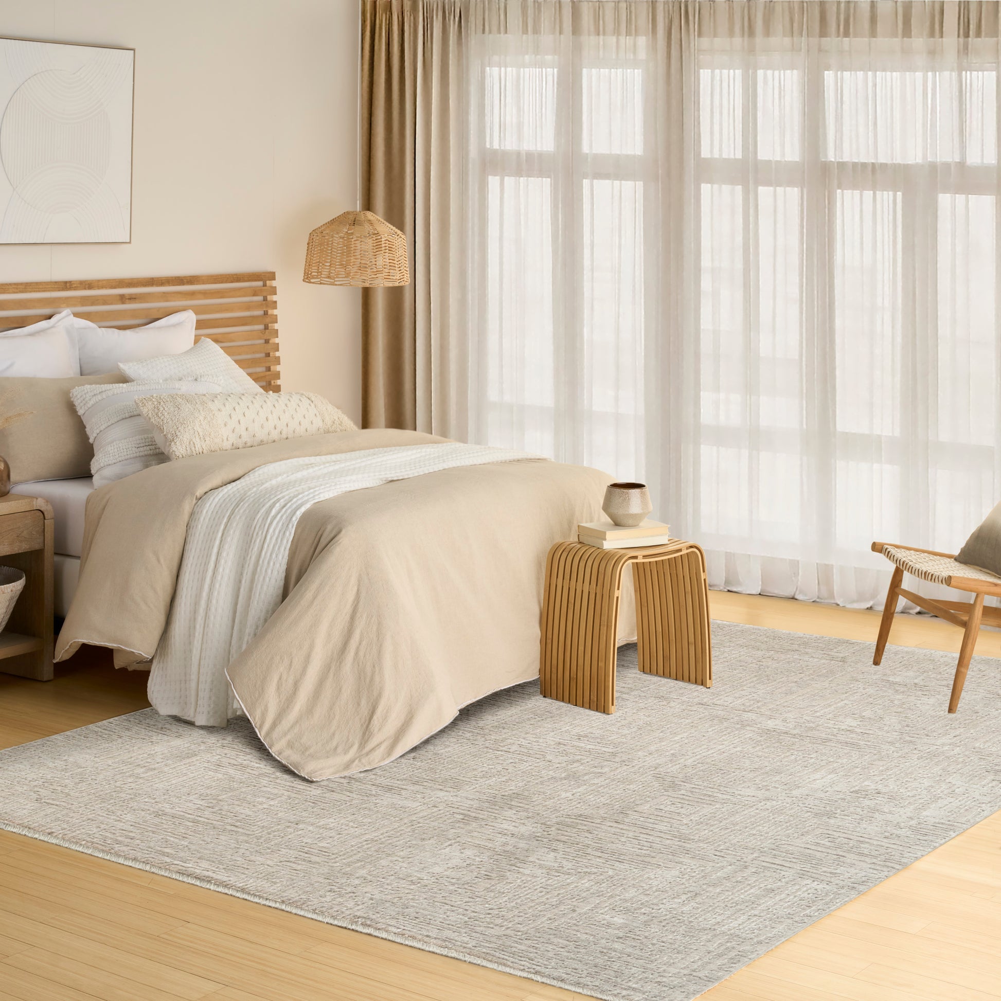 Neutral beige bedroom with wooden slat headboard, layered bedding, woven lamp, light rug & sheer curtain windows.