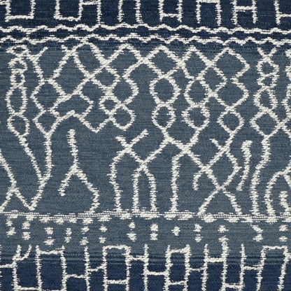 Blue woven pillow with white geometric lattice pattern and decorative border motifs, 24" x 24".