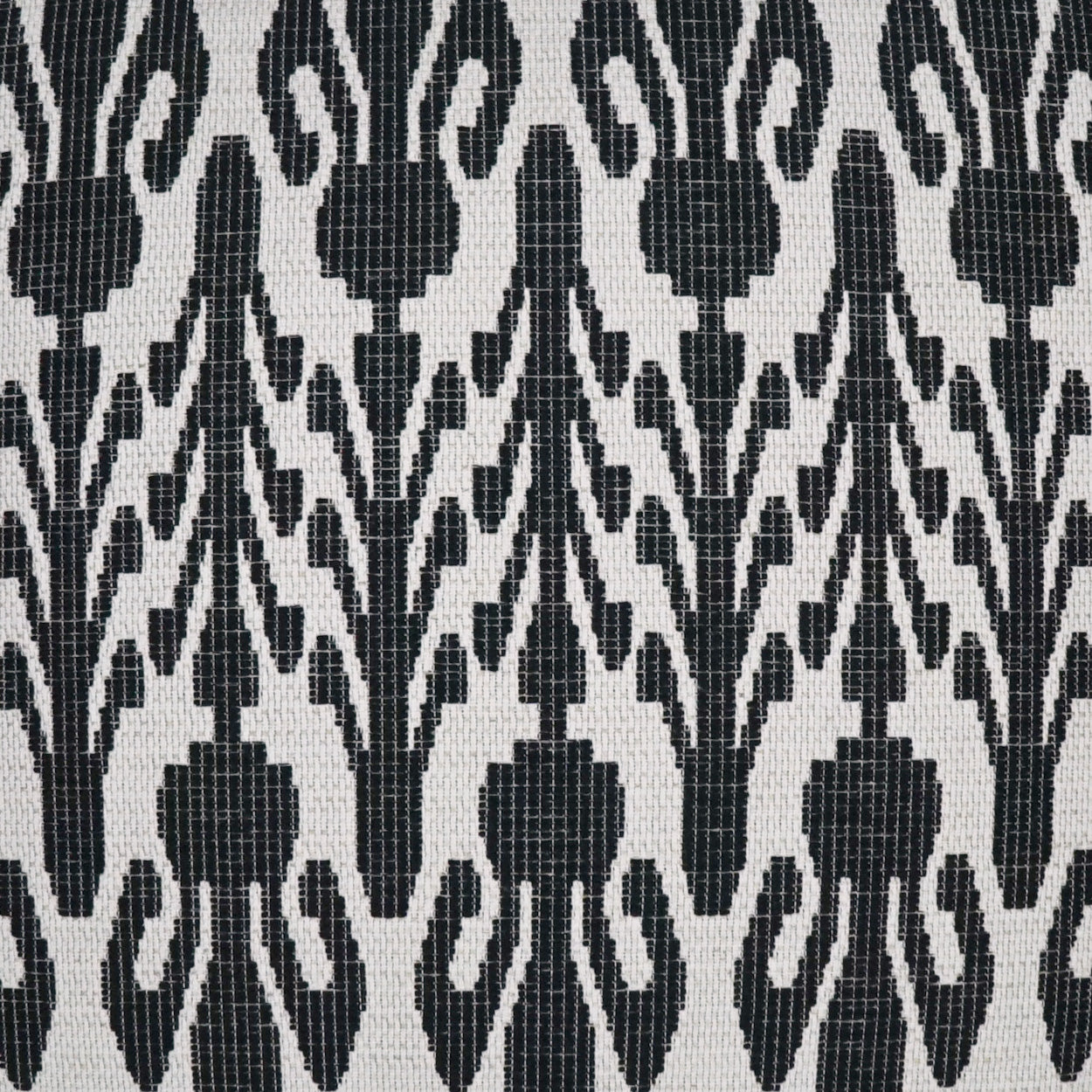 Close-up of black and white damask-inspired fabric with repeating floral-vine motifs