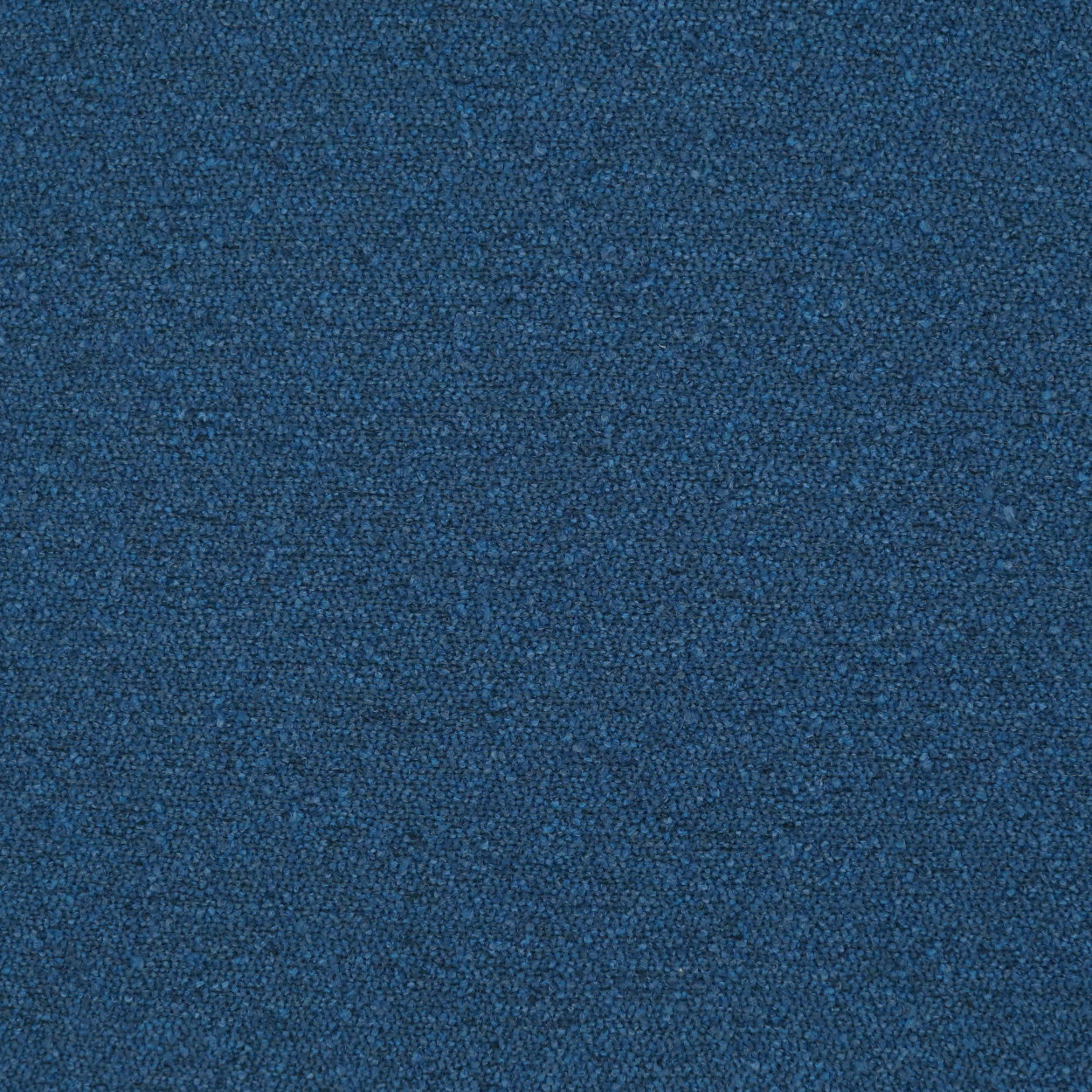 Blue textured pillow with a tight looped weave.